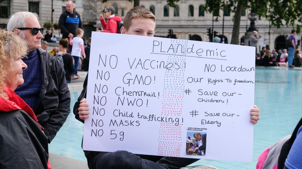 A sign being held at Saturday's protest saying "no vaccines, no GMO, no child trafficking, no NWO"