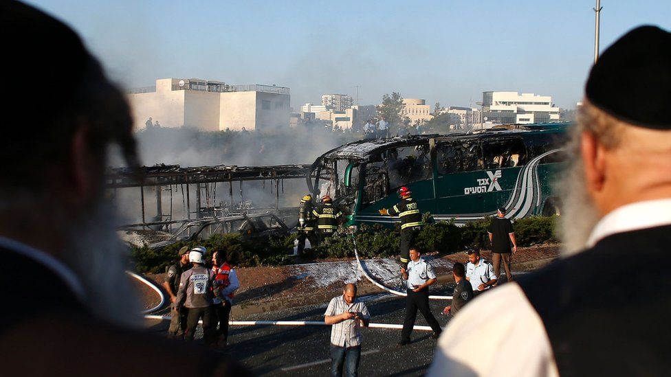 Jewish men look at the site of an explosion on bus in Jerusalem on April 18, 2016.