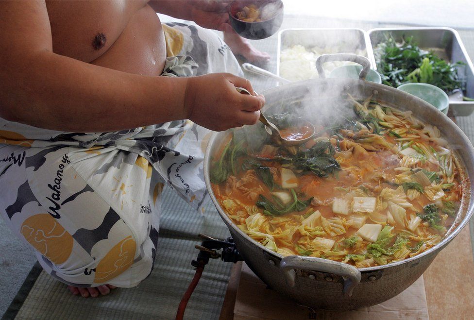 A sumo wrestler dishes up 'chanko-nabe' during a 'Sumo Diet Campaign' event at Musashigawa Sumo Stable on March 1, 2007 in Osaka, Japan.