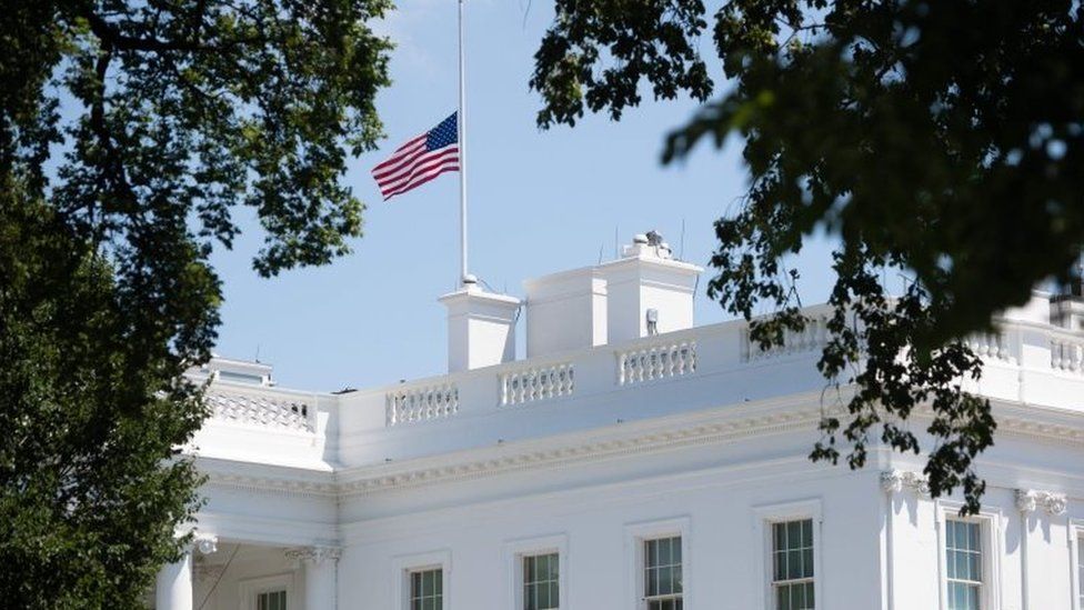 The American flag flies at half staff over the White House in Washington, DC, July 18, 2020