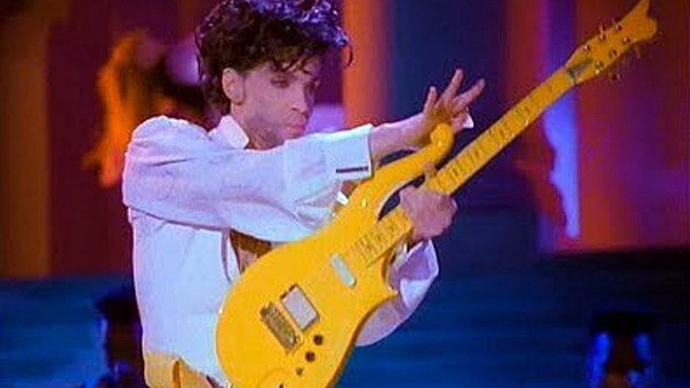 Photo provided by Heritage Auctions shows Prince playing his Yellow Cloud electric guitar