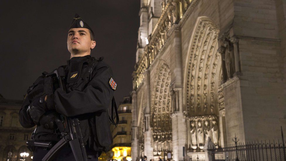 A French gendarme in front of the Notre Dame cathedral