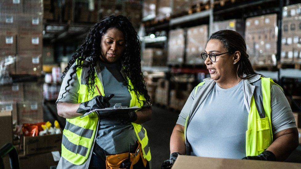 Two women working in a warehouse