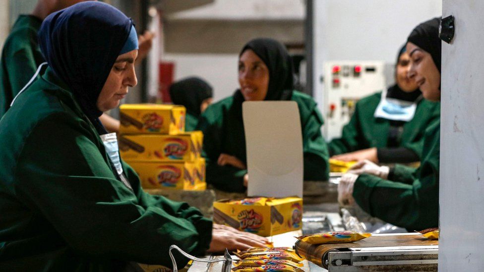 Palestinian women work at a factory in the West Bank city of Ramallah (17 June 2019)