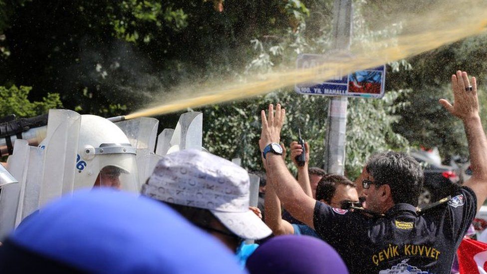 Riot police use pepper spray to push back a group of Uighur protesters who try to break through a barricade outside the Chinese Embassy in Ankara, Turkey, Thursday, June 9. 2015
