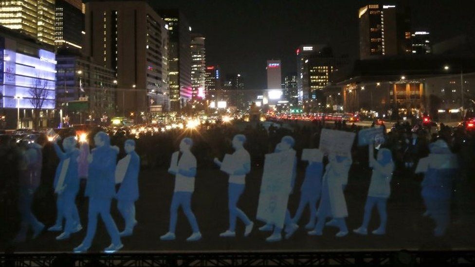 Holograms of protesters are shown on a screen during a rally in Seoul. Photo: 24 February 2016