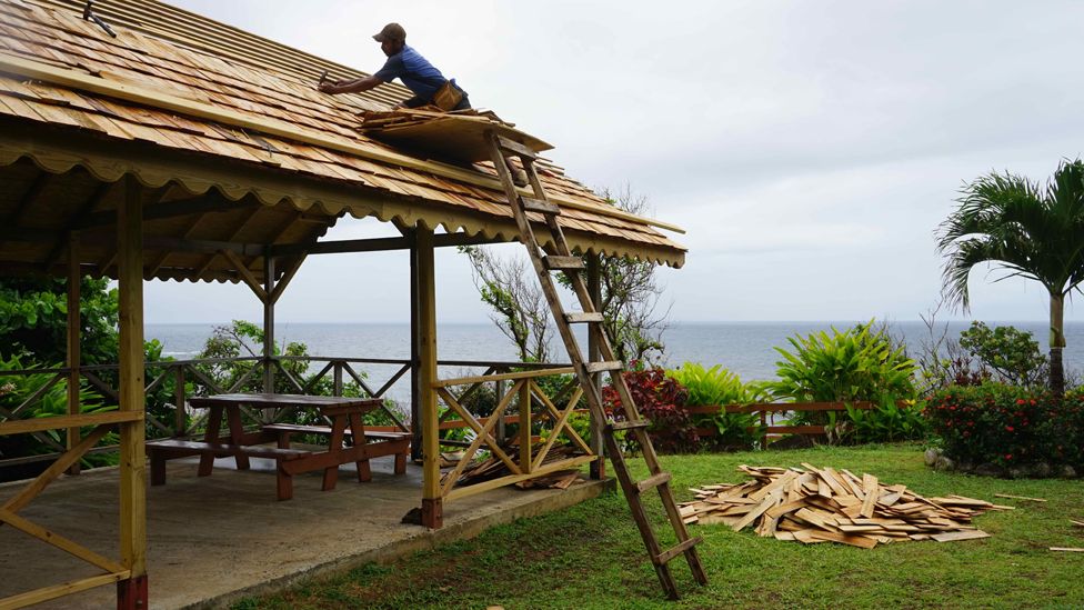 A man fixes the roof in Salybia