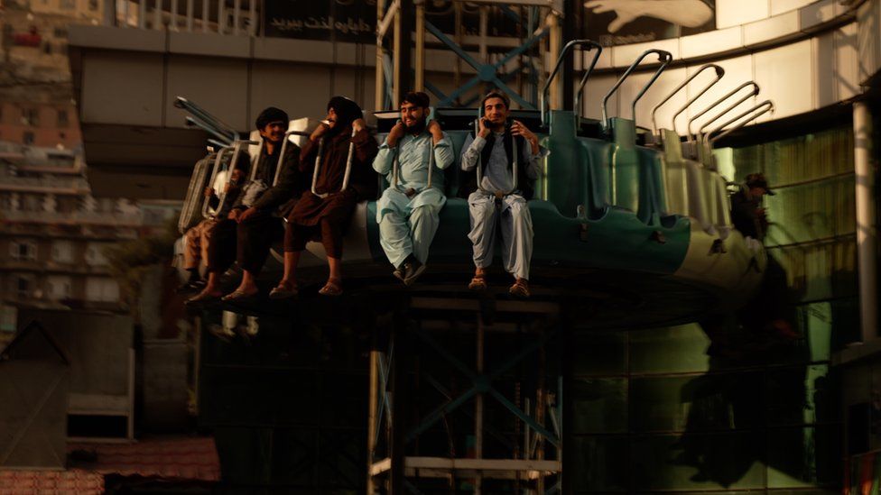 Афганские мужчины катаются в парке развлечений в Кабуле