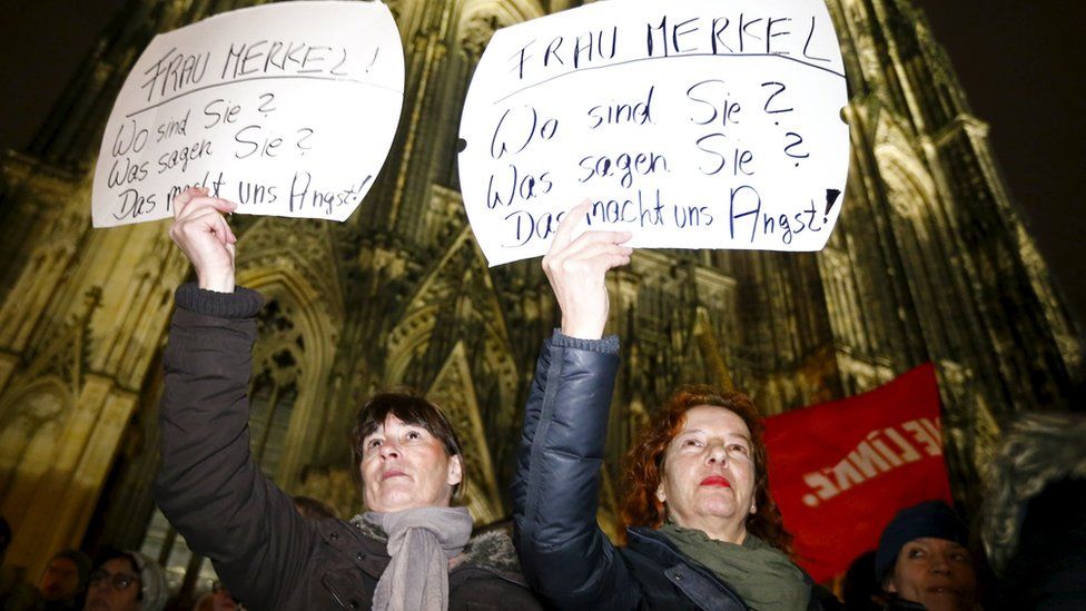 Women in Cologne hold placards saying "Mrs Merkel: Where are you? What do you say? This alarms us"