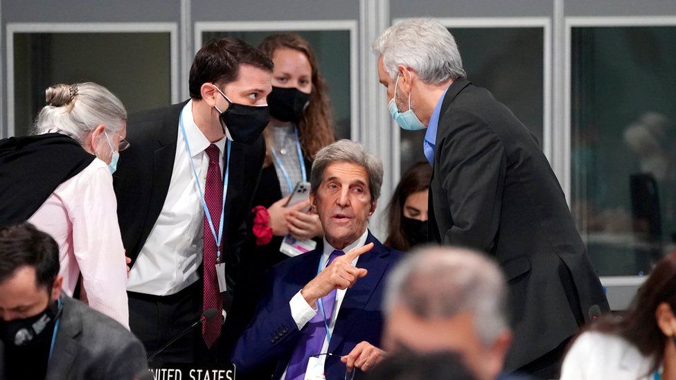 US Special Presidential Envoy for Climate John Kerry makes a hand gesture as his team discuss matters during a informal stock taking plenary session, during an "overun" day of the Cop26 summit in Glasgow