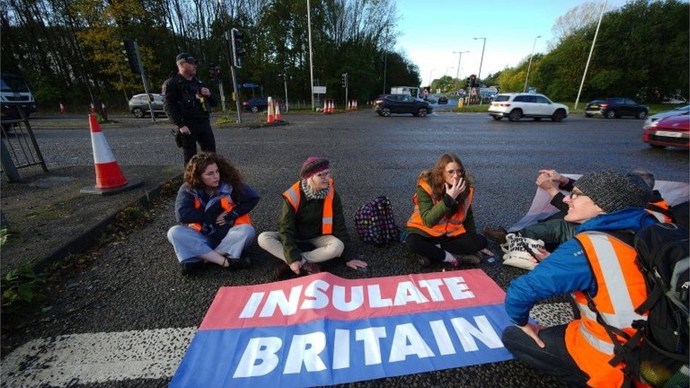Protesters from Insulate Britain blocking a road near Manchester Airport