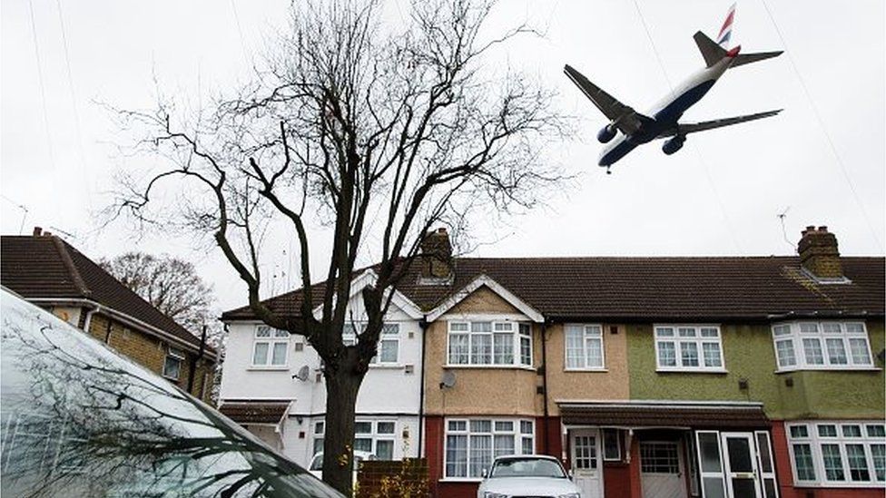 An aircraft flies over residential houses in Hounslow as it prepares to land at London Heathrow