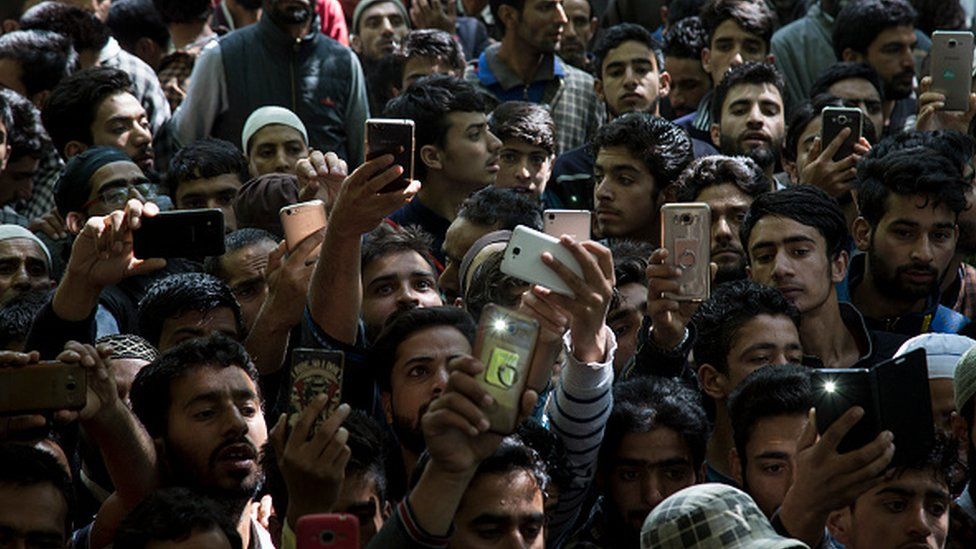 Kashmiri villagers click pictures with their mobile phones during the funeral of a teenager Adil Magray at Shopian, about 60 kilometers (38 miles) south of Srinagar, Indian-administered Kashmir, Wednesday, June 7, 2017