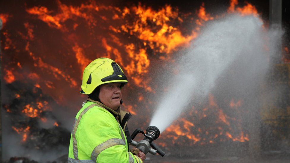 A firefighter in front of a large fire