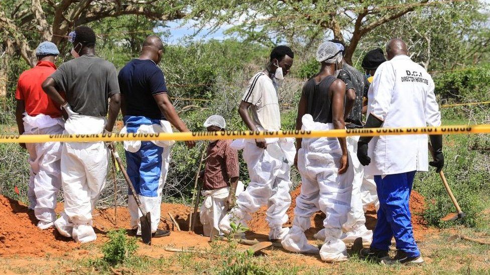 Kenyan detectives and forensic experts examine a grave site in the Shakahola forest in Kilifi, Kenya