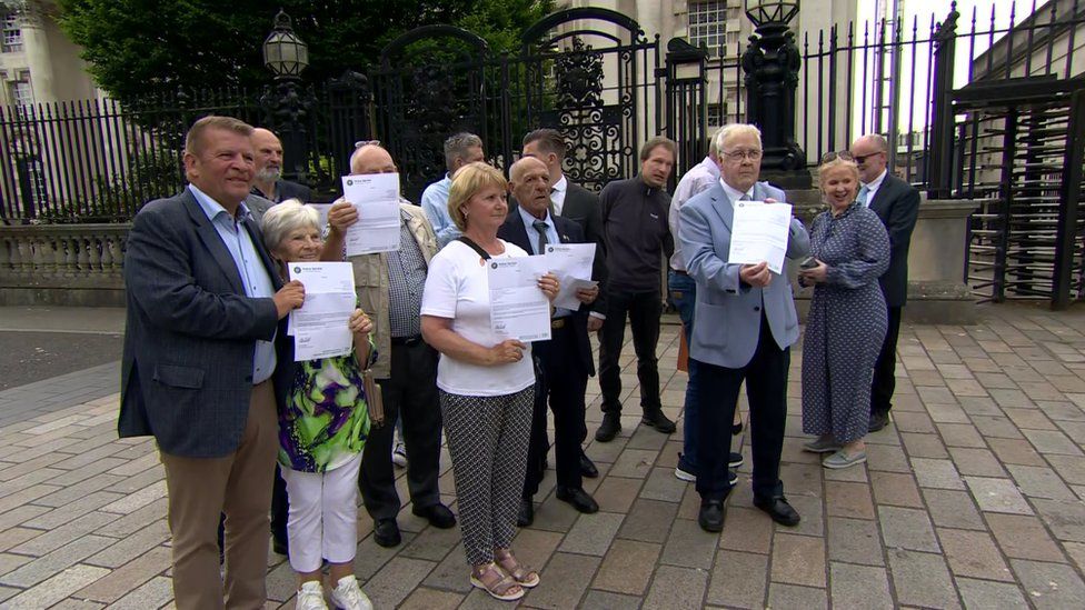 Some of the Hooded Men and families gathered after the announcement was made