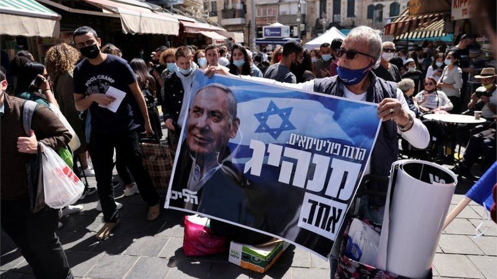 Мужчина держит плакат в поддержку Нетаньяху в Иерусалиме (21.03.21)