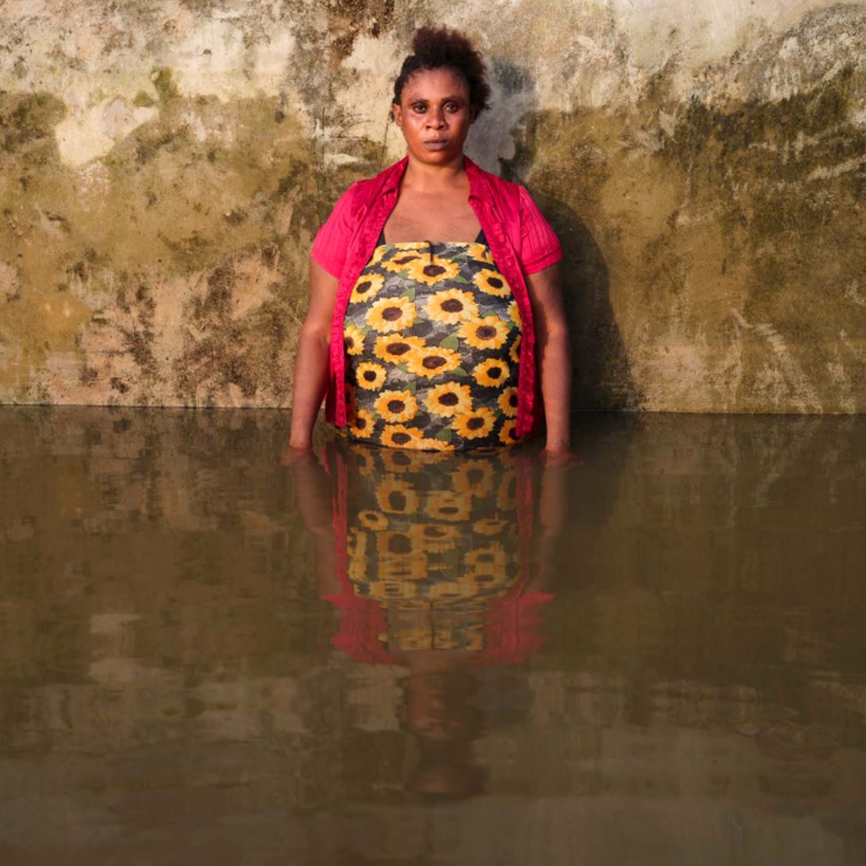 Фиделия Шедрак стоит в паводковой воде в своем доме в муниципалитете Йенагоа, штат Байелса, Нигерия, ноябрь 2022 г.