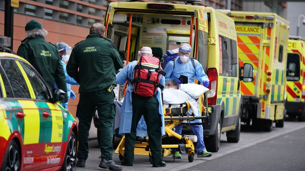 Paramedics transfer a patient from an ambulance into the Royal London Hospital