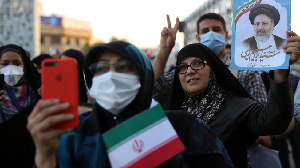 Supporters of Ebrahim Raisi hold a photo of him at a rally in Tehran, Iran, following his presidential election victory (19 June 2021)