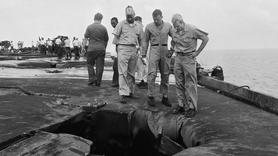 John McCain (r) surveying the damage to the USS Forrestal