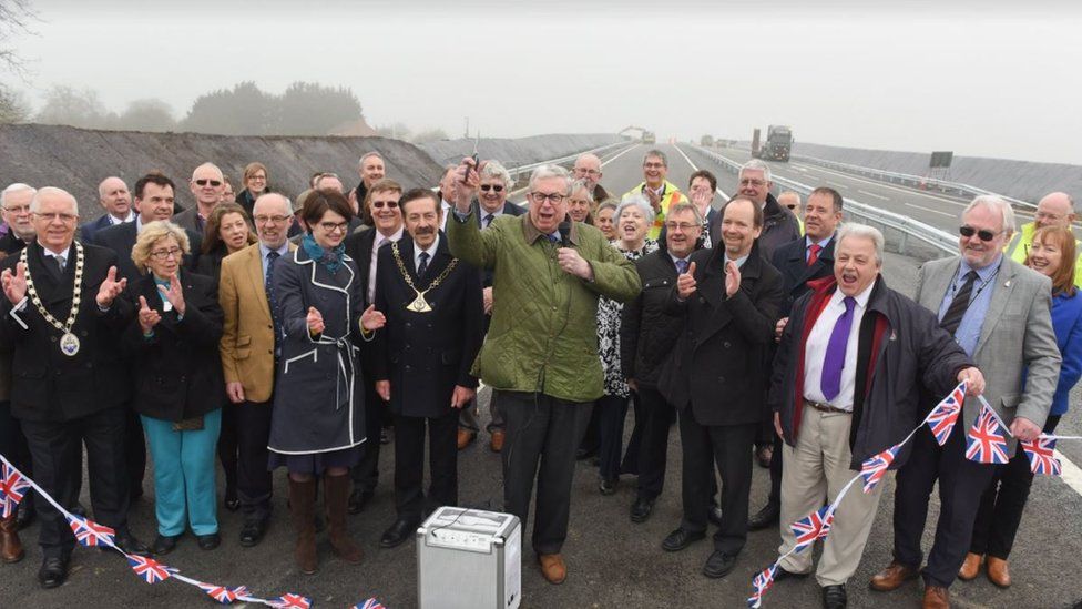 Broadland MP Keith Simpson cuts the ribbon to the final section of road