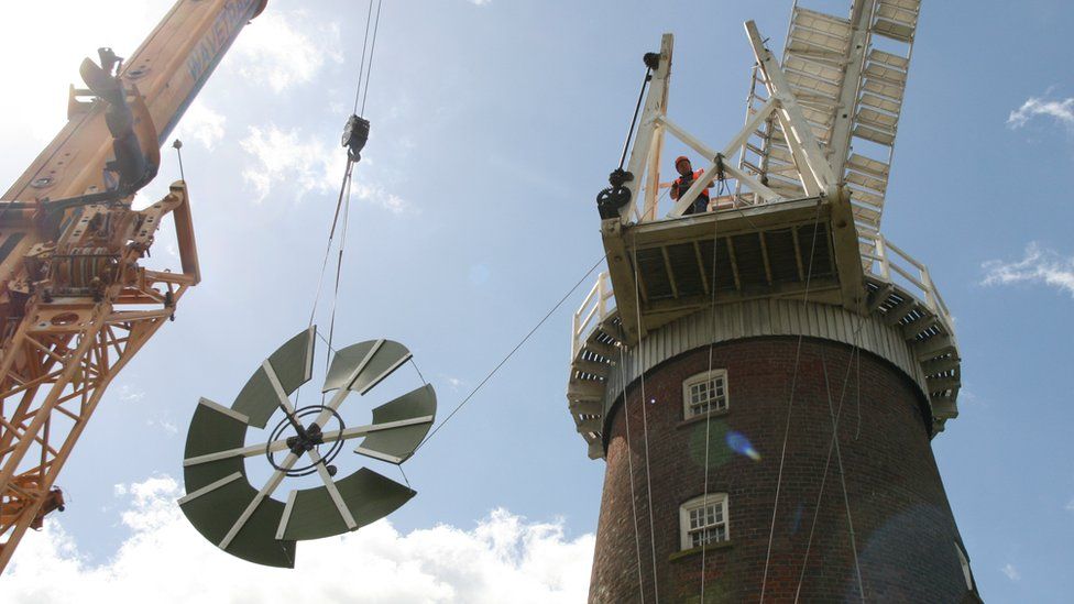 A crane hoists the new fantail to the top of Buttrum's Mill in Woodbridge, Suffolk