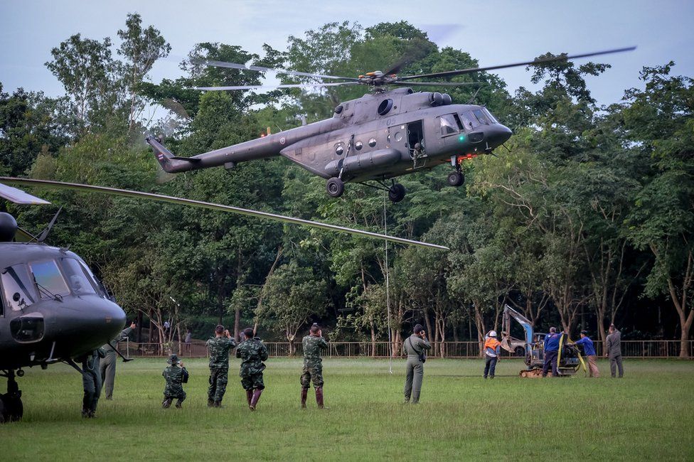 Helicopter from Thai air force carry a mini excavator to the mountain top where they are trying to make a hole to get into Tham Luang Nang Non cave