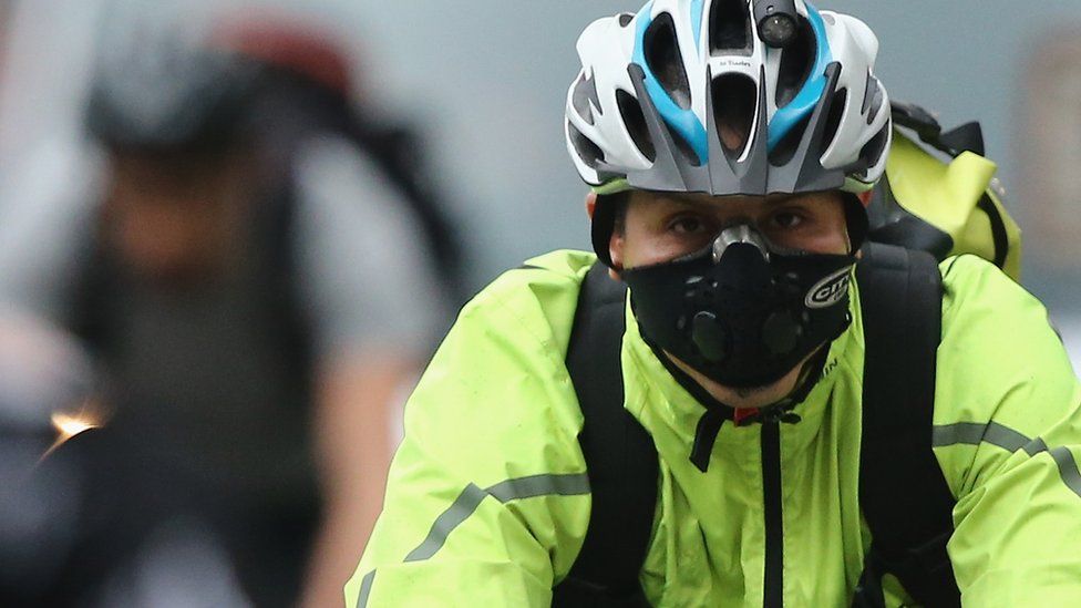 A cyclist wearing a breathing mask in central London