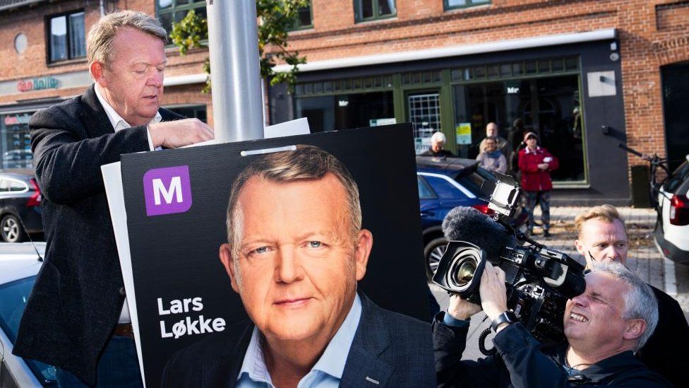 Chairman of the Moderates Lars Lokke Rasmussen (C) puts up election posters and offers muffins, coffee and a chat on the main street in Haslev, Denmark, 08 October 2022