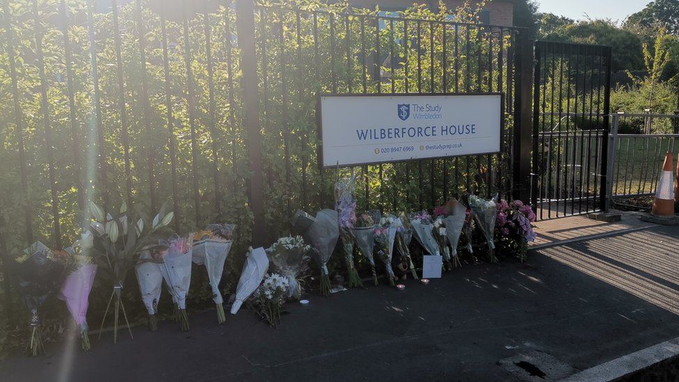 Flowers outside gates underneath 'Wilberforce House' sign