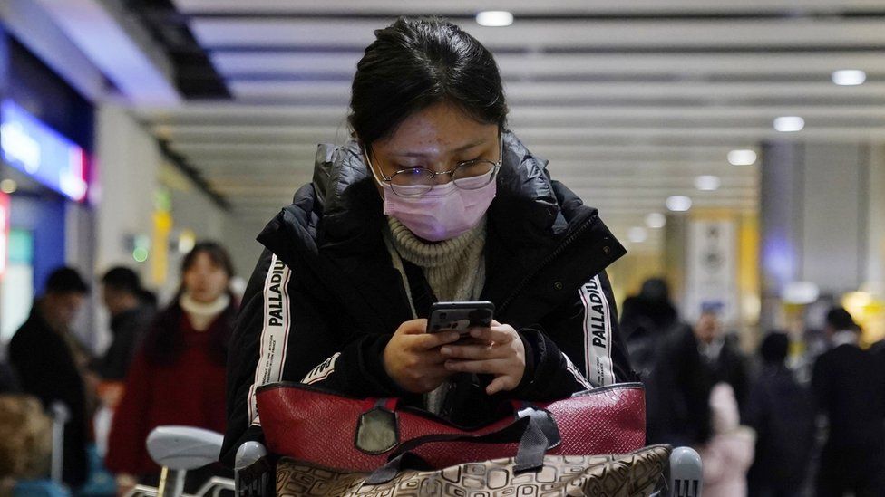 A passenger arrives wearing a mask at Terminal 4, Heathrow Airport, London