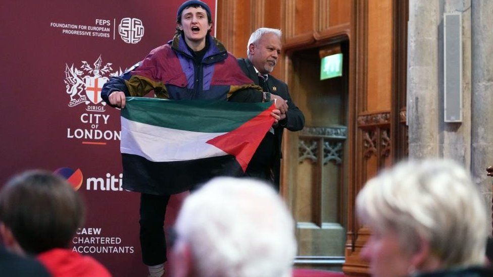 A protester interrupts the shadow foreign secretary's speech