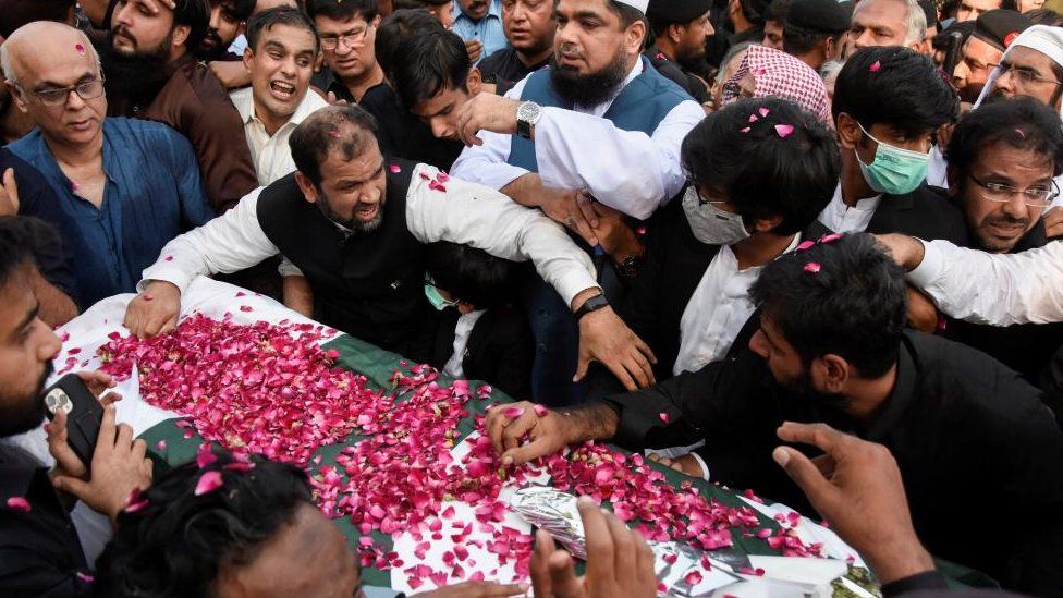 Мужчины собираются вокруг гроба, присутствовать на похоронах журналиста Аршада Шарифа, убитого в результате перестрелки с полицией в Кении, в мечети Фейсал в Исламабаде, Пакистан 27 октября 2022 г.