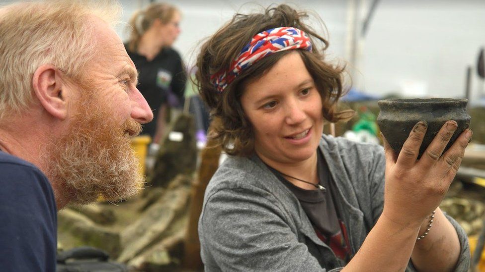 Archaeologists examine a bronze age bowl