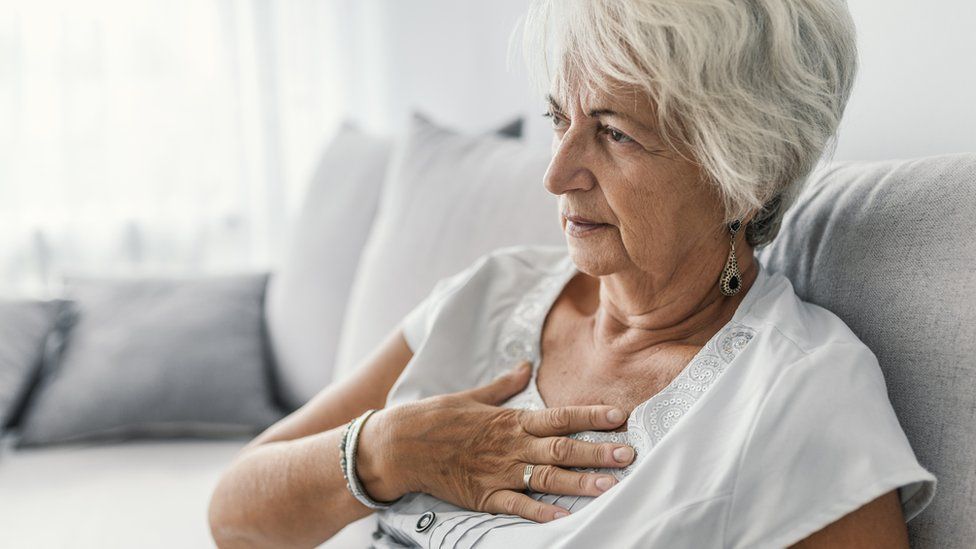 Older woman clutching her heart