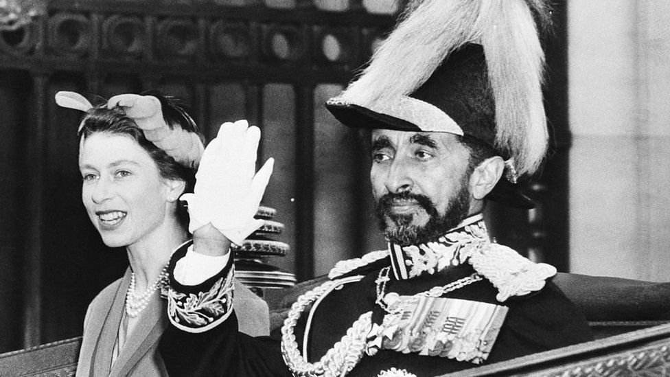 Queen Elizabeth II of England rides in an open carriage with Ethiopia's Emperor Haile Selassie. Entering Whitehall from Parliament Square on the Buckingham Palace. The Queen went to the station to welcome the Emperor as he arrived in the British capital October 15th for a three-day state visit (10/15/54)