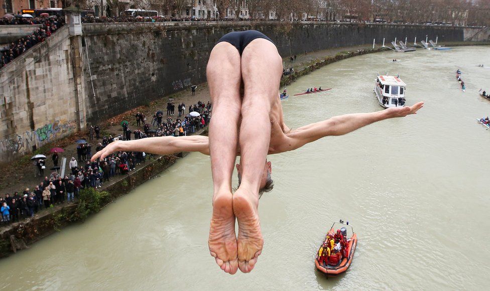 Marco Fois of Italy dives into the Tiber River from the Cavour bridge in Rome, Italy, 1 January 2018
