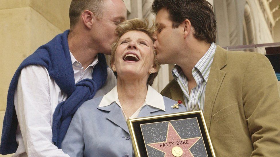 Patty Duke receives kiss from sons, Mackenzie (L) and Sean Astin following unveiling ceremony honouring Duke with a star on the Hollywood Walk of Fame in Los Angeles, California. 2004