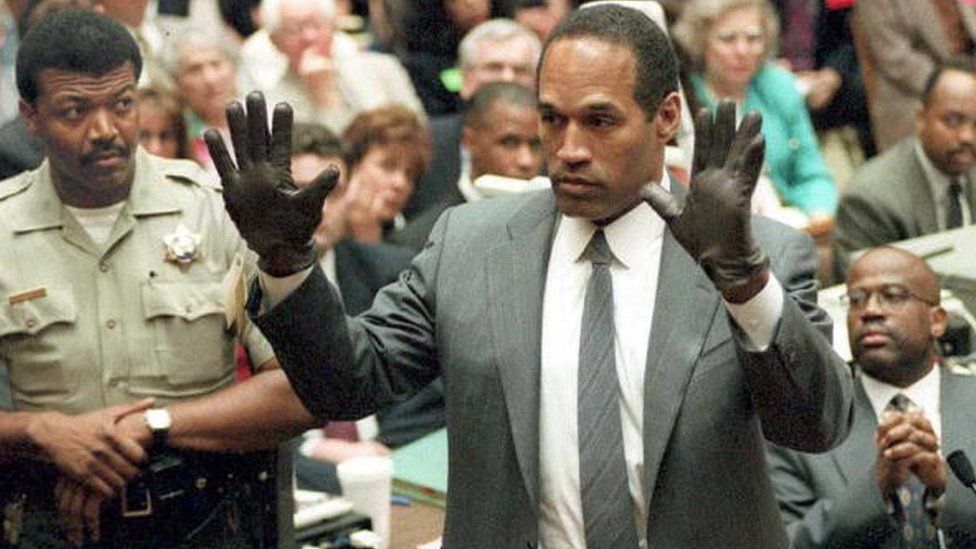 OJ Simpson shows the jury a pairs of gloves he was asked to wear during the trial