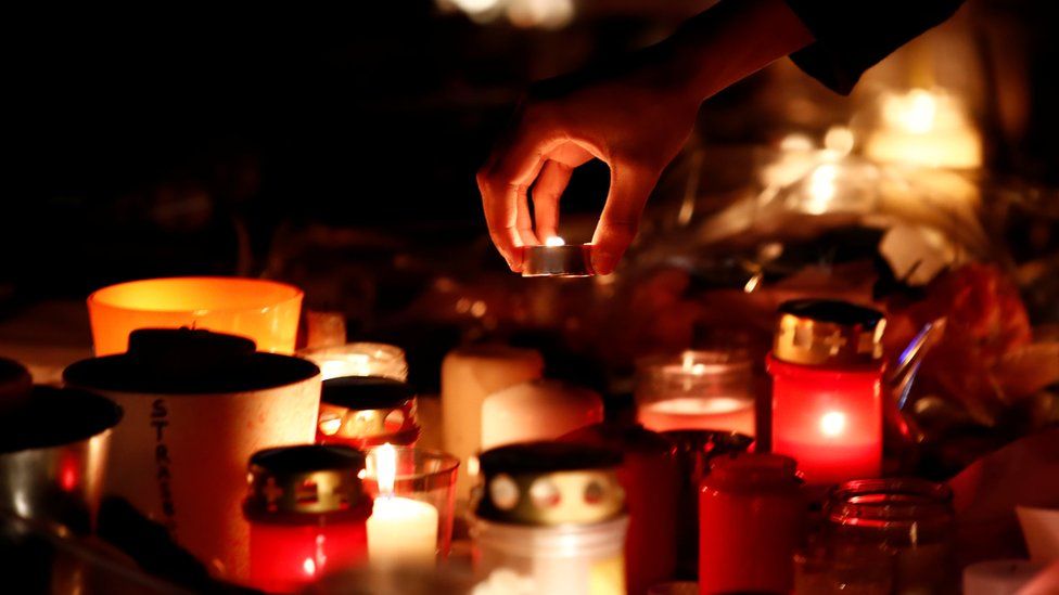 People light candles in tribute to the victims of the deadly shooting in Strasbourg, France, December 13, 2018.