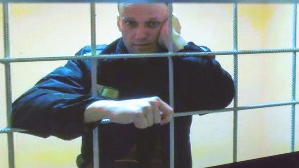 Russian opposition leader Alexei Navalny is seen on a screen via a video link from the IK-2 corrective penal colony in Pokrov during a court hearing to consider an appeal against his prison sentence in Moscow