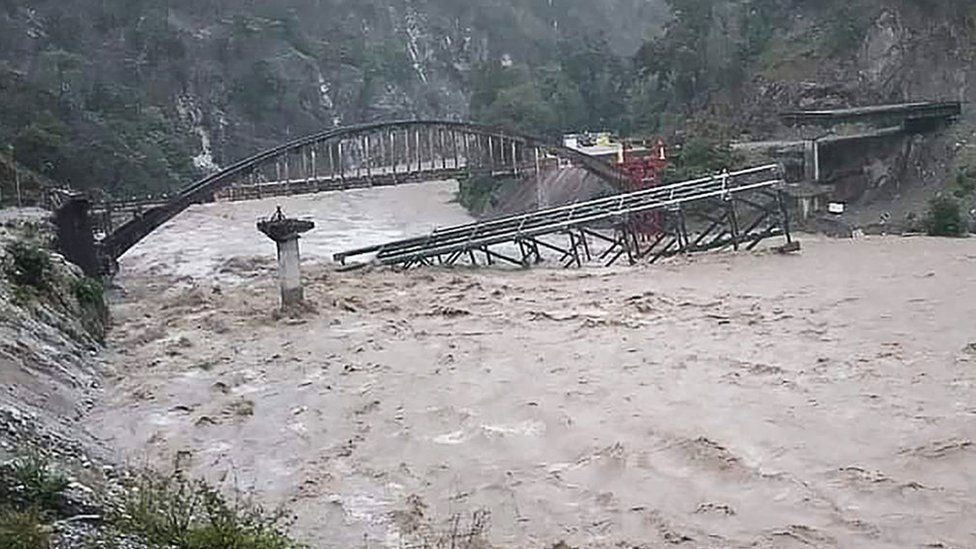 An under construction bridge is seen collapsed on a river along a national highway between Pithoragarh and Champawat, in Chalthi on October 19, 2021 following heavy rainfalls in northern India