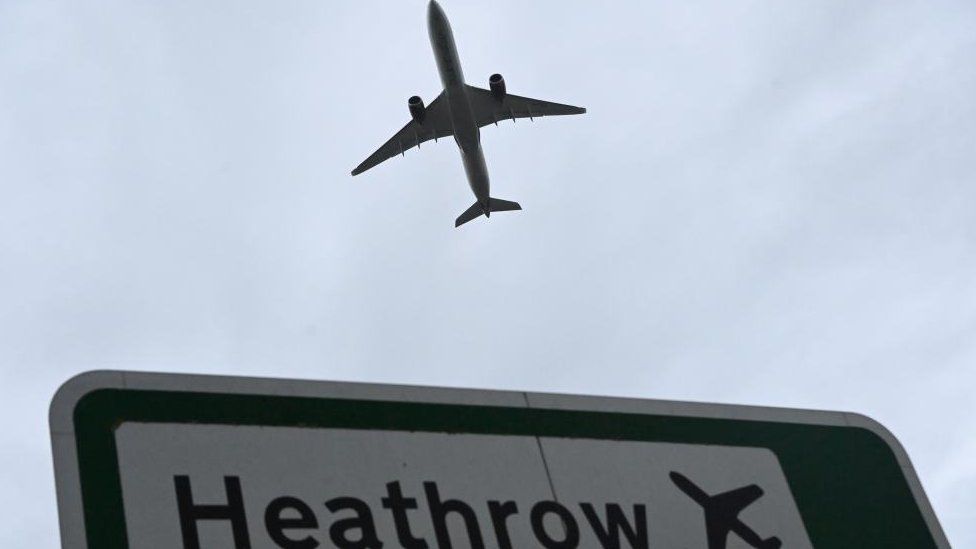 Plane over Heathrow sign