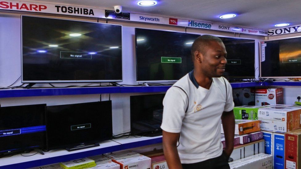 A Kenyan electronics dealer stands by blank screens that should be playing the three suspended channels