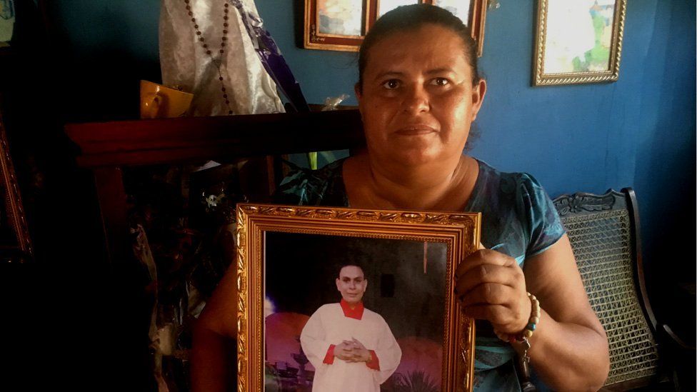 Ivania holds up a photo of her son Sandor who was killed by a bullet