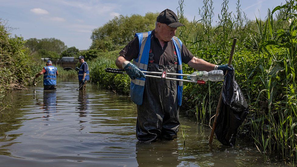 A volunteer takes part in a river cleanup in London