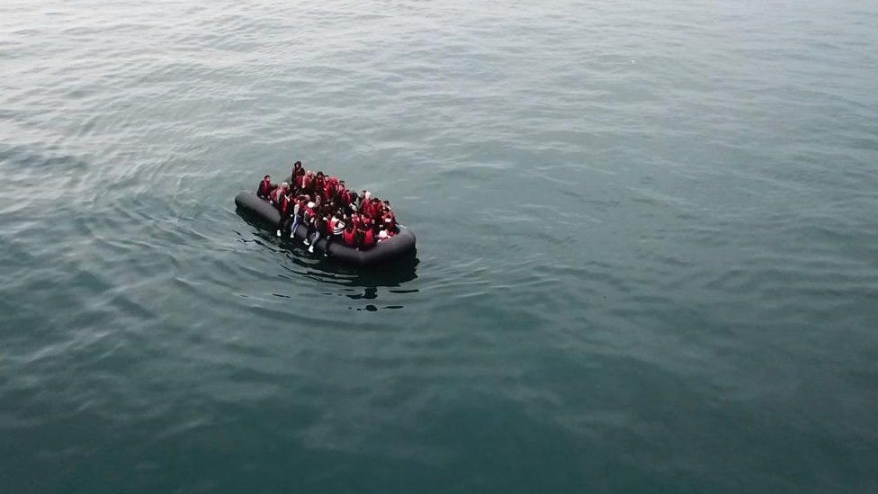 A representation   taken with a drone shows migrants crossing the English Channel connected  a tiny  boat