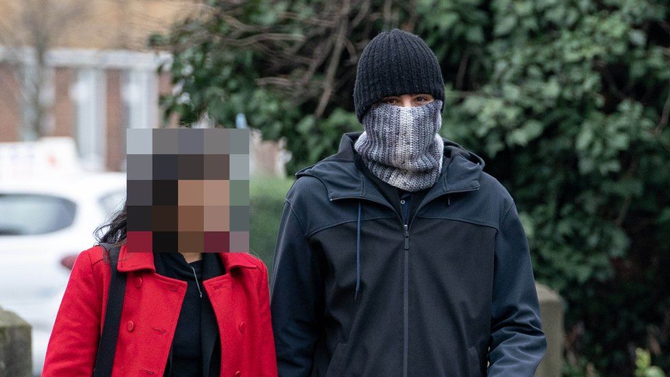 Photo of PC Hussain Chehab wearing a hat and a scarf pulled up over his mouth and nose, pictured with an unidentified woman.