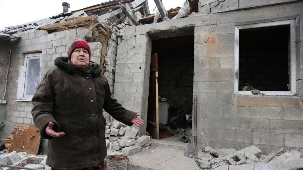 A resident of Avdiivka, eastern Ukraine, stands outside her destroyed house. Photo: 2 February 2017